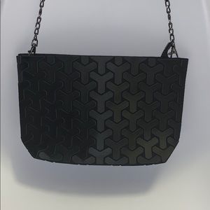 A black Patrizia Luca crossbody purse.